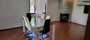 ein Esszimmer mit einem Glastisch und weißen Stühlen in der Unterkunft Nice House next to a beautiful park in Tirana