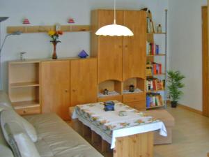 ein Wohnzimmer mit einem Tisch und einem Bücherregal in der Unterkunft Ferienhaus Mirada in Blankenhagen