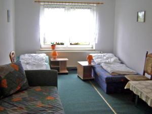 Pokój z 2 łóżkami, kanapą i oknem w obiekcie Ferienhaus Mirada w mieście Blankenhagen