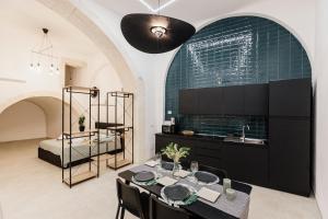 uma cozinha com uma mesa e uma cama num quarto em I Dammusi di Via Vittorio Veneto em Siracusa