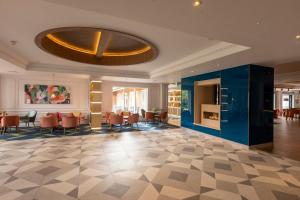 um átrio com uma área de refeições com cadeiras e mesas em Holiday Inn Guildford, an IHG Hotel em Guildford