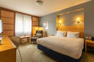a hotel room with a bed and a chair at Holiday Inn Guildford, an IHG Hotel in Guildford