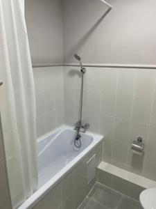 a white bathroom with a tub and a shower at Жилой Комплекс Акжайык in Astana +44 photos