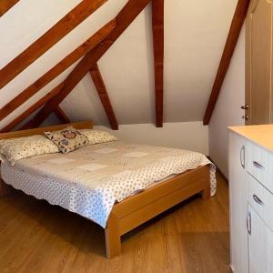 a small bed in a room with wooden ceilings at Vikendica Drina Hill Loznica in Loznica