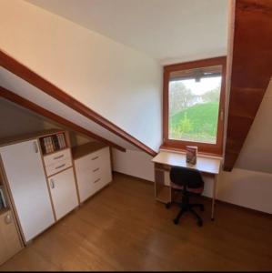 Zimmer im Dachgeschoss mit einem Schreibtisch und einem Fenster in der Unterkunft Vikendica Drina Hill Loznica in Loznica