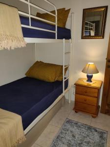 een slaapkamer met 2 stapelbedden en een tafel met een lamp bij St paul's in St Paul's Bay