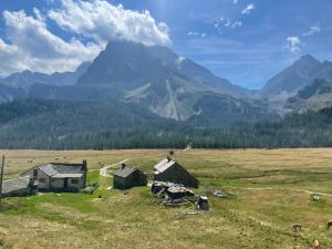 an open field with two barns and a mountain at CASA BETTO in San Domenico