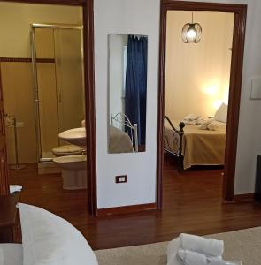 Habitación con baño con espejo y cama. en Dimora Celeste, en Ostuni