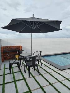 a patio with a table and chairs and an umbrella at Free Disney Hotstar Private Pool Lotus Homestay Alor Setar for MUSLlM in Alor Setar +9 photos