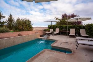 uma piscina com mesa e cadeiras e um guarda-sol em Hotel Cardamomo Sigüenza em Carabias