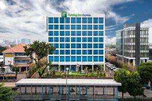 雅加达Holiday Inn Express Jakarta Matraman by IHG的一座高楼，楼顶有标志
