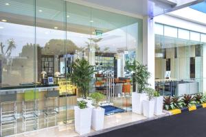 Holiday Inn Express Jakarta Matraman, an IHG Hotel في جاكرتا: لوبي مبنى فيه نباتات الفخار
