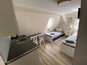 um pequeno quarto com uma cozinha e uma sala de estar em Altstadt Pension Herborn em Herborn