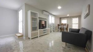 a living room with a couch and a television at La casa de la tinaja piscina y chimenea by Toledo AP in Villamiel de Toledo