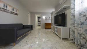 a living room with a couch and a flat screen tv at La casa de la tinaja piscina y chimenea by Toledo AP in Villamiel de Toledo