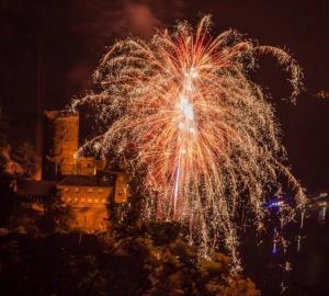 uno spettacolo di fuochi d'artificio di notte di fronte a un edificio di Das Loreley Weinstuebchen a Sankt Goarshausen