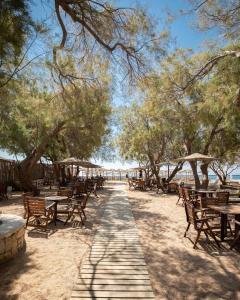 uma fila de mesas e cadeiras na praia em Agrari Ninemia Mykonos em Agrari