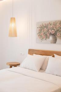 a bedroom with a bed and a painting on the wall at Agrari Ninemia Mykonos in Agrari