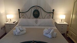 a bedroom with a bed with towels and two lamps at Dimora Celeste in Ostuni