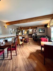 a dining room with wooden tables and chairs at The Reindeer Inn in Sandtoft