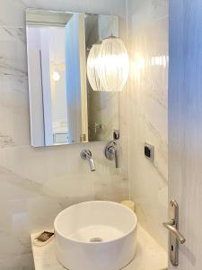 a white bathroom with a sink and a mirror at Studios Estrella del mar in Skala Potamias