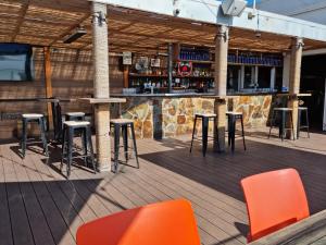 un bar con mesas y sillas naranjas en una terraza en Seaford Luxe Beach House 2023 BDC Traveller award winner en Seaford