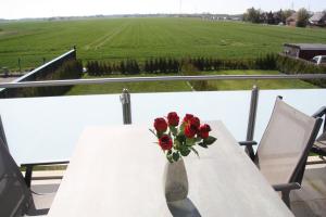 un jarrón de flores sobre una mesa con un campo en Seeblick 8 - Luxus direkt am Hafen von Norddeich en Norddeich