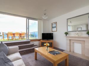 a living room with a fireplace and a tv at Apartment at Morningside Hotel in Torquay
