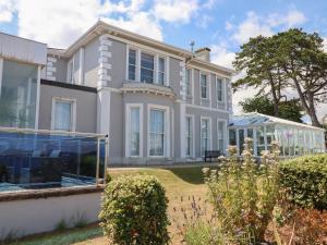 a large white house with a garden in front of it at Apartment at Morningside Hotel in Torquay