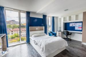 a bedroom with a bed and a large window at Destiny Student - Holyrood (Brae House) in Edinburgh