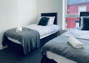 A bed or beds in a room at RUTLAND HOUSE 10 mins from Manchester City Ctr 4-Bedroom House