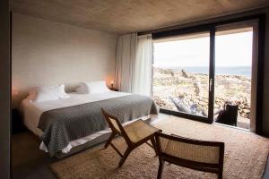 een slaapkamer met een bed en een groot raam bij Azores Wine Company in Cais do Mourato