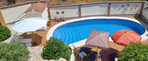 een afbeelding van een zwembad met parasols bij Maravilloso Guesthouse in Fuengirola