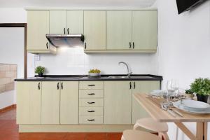 a kitchen with white cabinets and a wooden table at Casa Diego in Soo