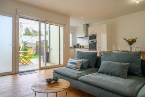 a living room with a couch and a table at LA P'TITE VANNETAISE - Petite maison au bord de l'eau à Conleau avec vélos in Vannes
