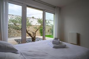 ein Schlafzimmer mit einem Bett und einem großen Fenster in der Unterkunft LA P'TITE VANNETAISE - Petite maison au bord de l'eau à Conleau avec vélos in Vannes