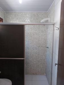 a shower with a glass door in a bathroom at Hospedagem Quinta do Correia in Penha