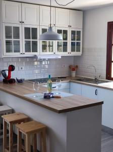 a kitchen with white cabinets and a wooden counter top at Lomas del Castillo, la casa de la isla in Caleta De Fuste
