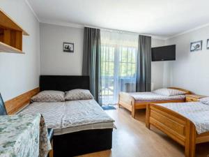 a bedroom with two beds and a television in it at Pokoje goscinne Orzechowo-Zapadle in Ustka
