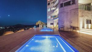 una piscina en la terraza de un edificio por la noche en J View Hotel en Seogwipo
