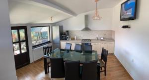 eine Küche und ein Esszimmer mit einem Glastisch und Stühlen in der Unterkunft Vila Panoramic Pestera in Peştera