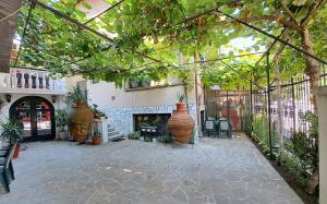 a patio with two large vases in a building at Каламанди in Asenovgrad