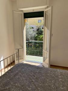 1 dormitorio con puerta abierta a un balcón en La casa di Andrea Grande Appartamento a due passi dalle spiagge, en Rapallo