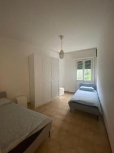 1 dormitorio con 2 camas y ventana en La casa di Andrea Grande Appartamento a due passi dalle spiagge, en Rapallo