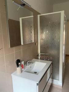 y baño con lavabo blanco y espejo. en La casa di Andrea Grande Appartamento a due passi dalle spiagge, en Rapallo