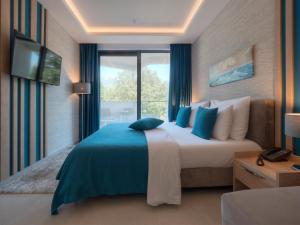 a bedroom with a large bed and a large window at Hotel Montenegro in Budva