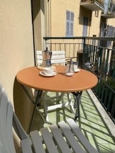 una mesa de madera en un balcón con sillas en La casa di Andrea Grande Appartamento a due passi dalle spiagge, en Rapallo