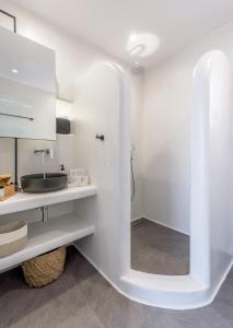 ein weißes Badezimmer mit einem Waschbecken und einem Spiegel in der Unterkunft Magic Klima IV in Klima