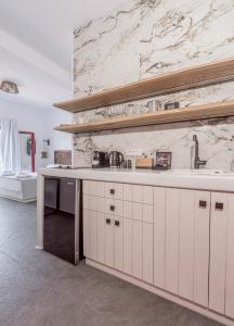 a kitchen with white cabinets and a marble wall at Magic Klima IV in Klima