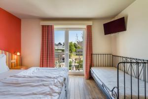 1 dormitorio con 1 cama, TV y ventana en Logie Bloemenlust en Wetteren